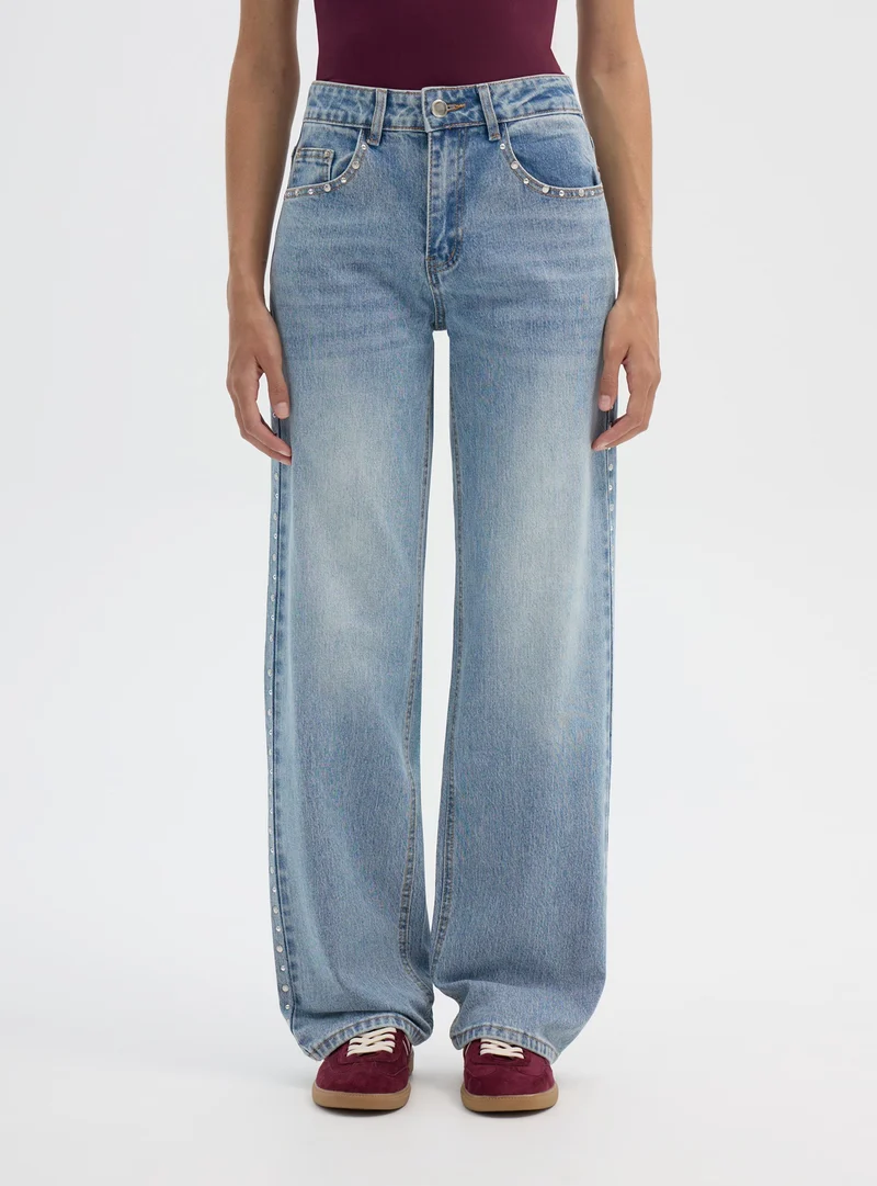 Jeans wide leg con borchie laterali