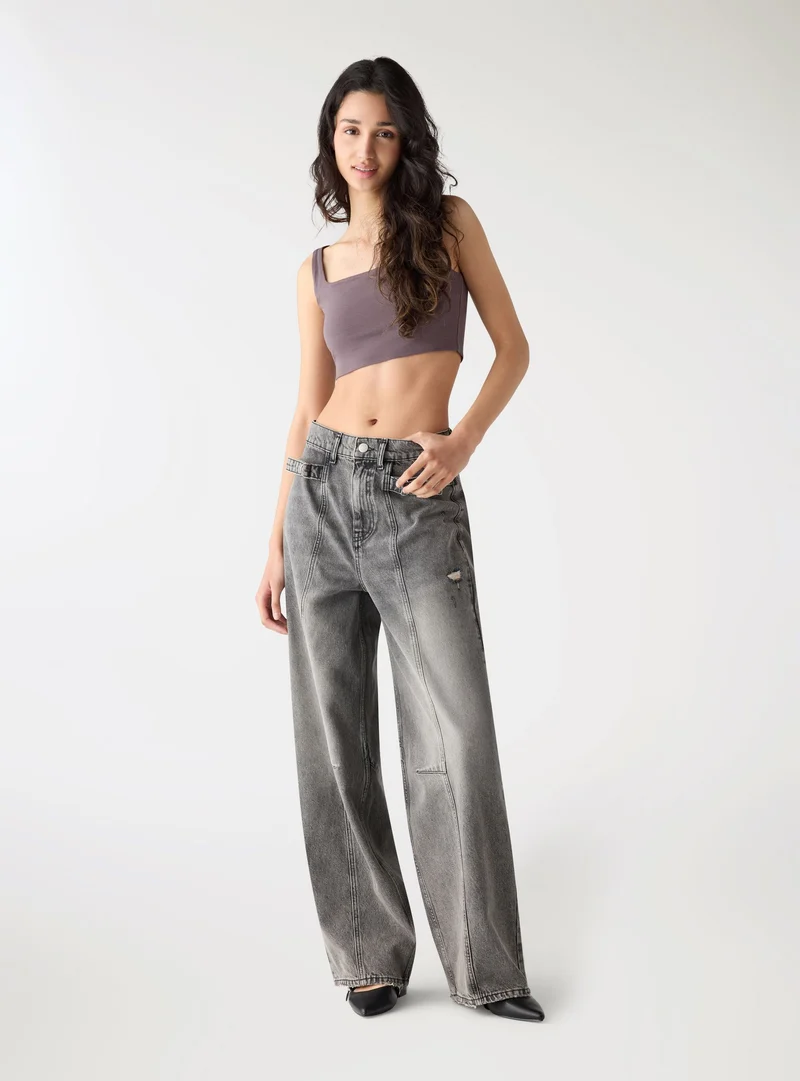 Jeans balloon con tagli e fibbie