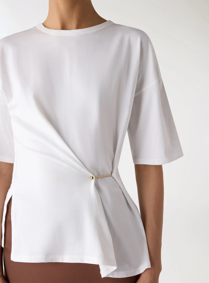 T-shirt con drappeggio e spilla