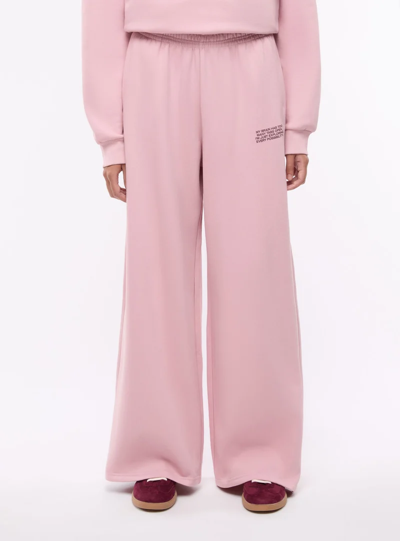 Pantaloni tuta wide leg con scritta