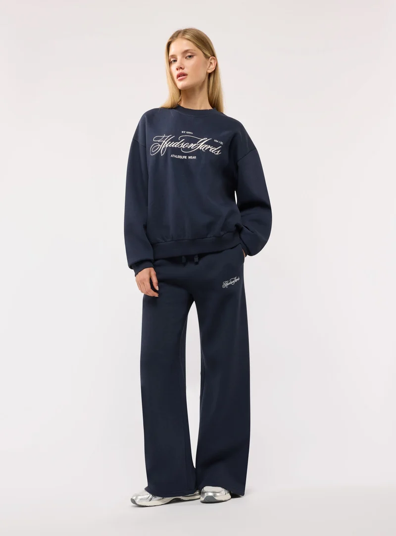 Pantaloni tuta wide leg con ricamo college