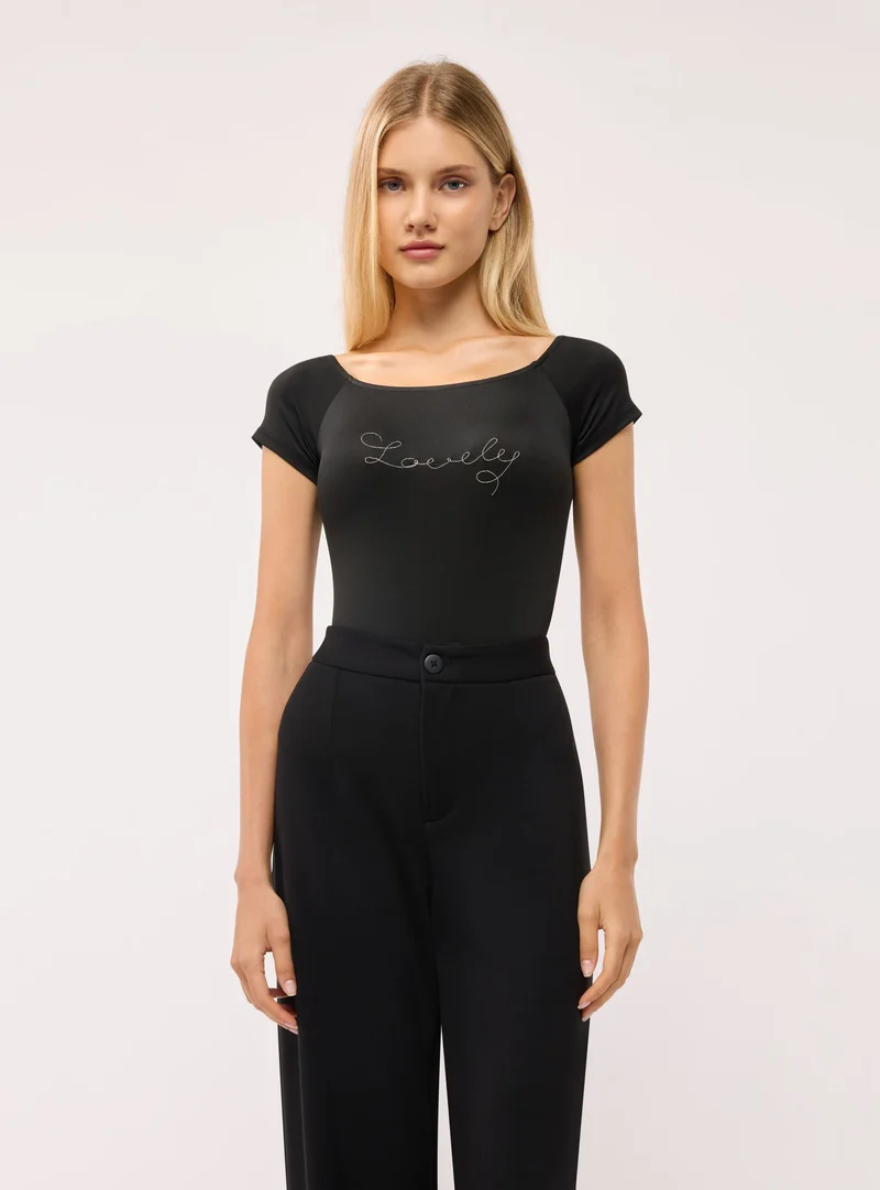 Body a spalle scoperte con scritta