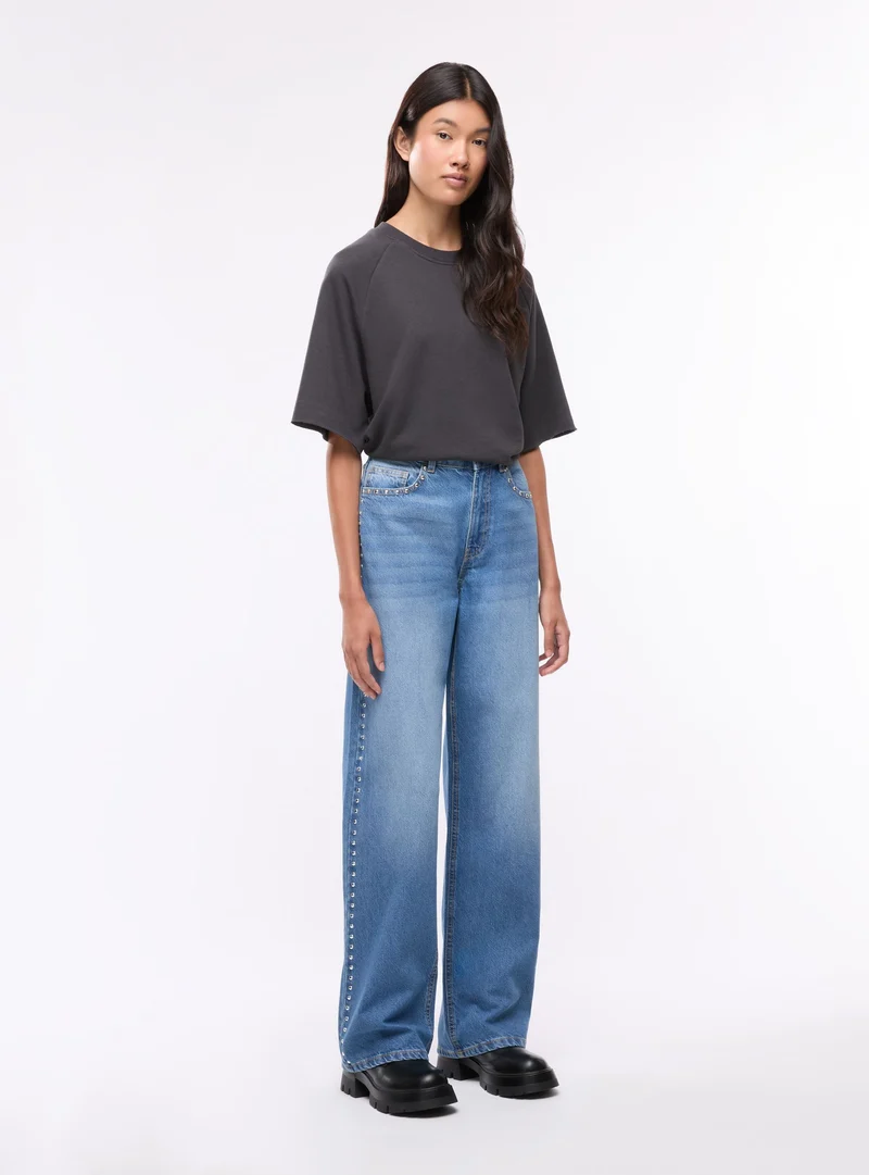 Jeans wide leg con borchie