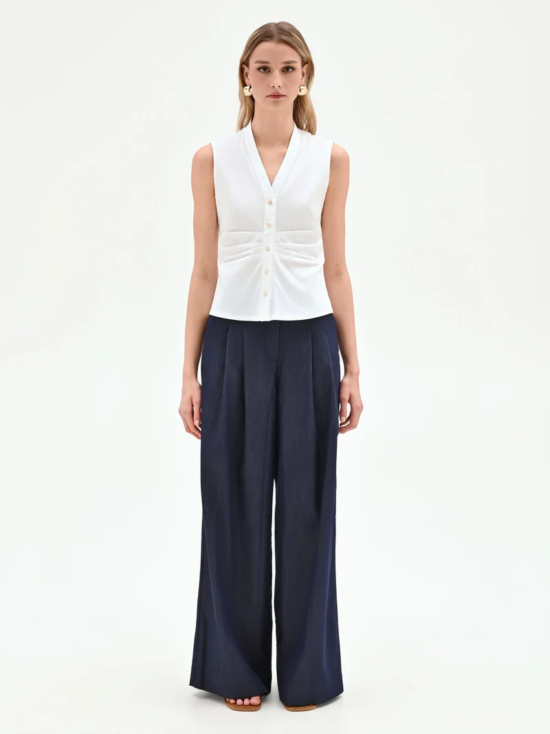 Camicia smanicata bianca con arriccio in vita