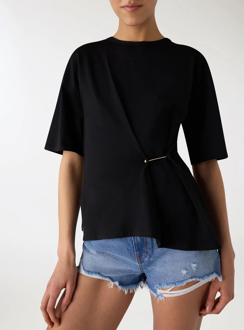 T-shirt con drappeggio e spilla