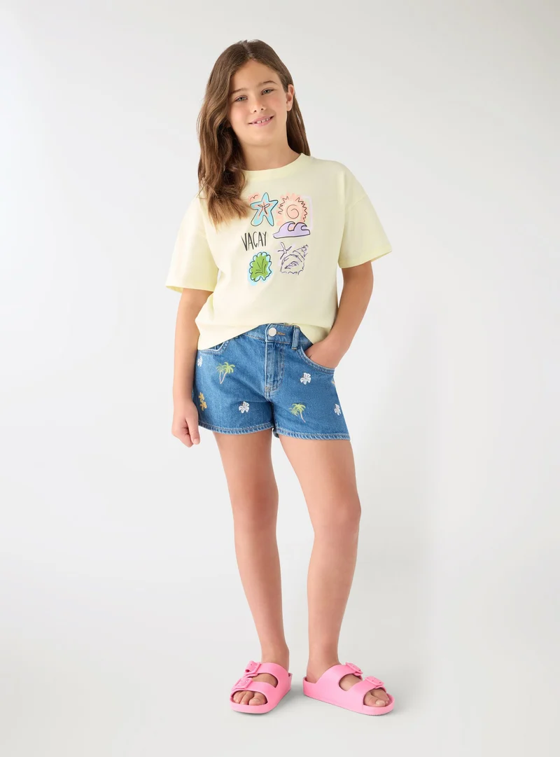 Shorts jeans con ricami tropicali