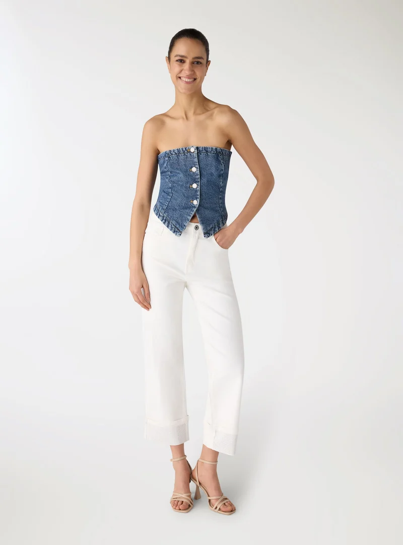 Jeans a tinta unita con risvolti e strass