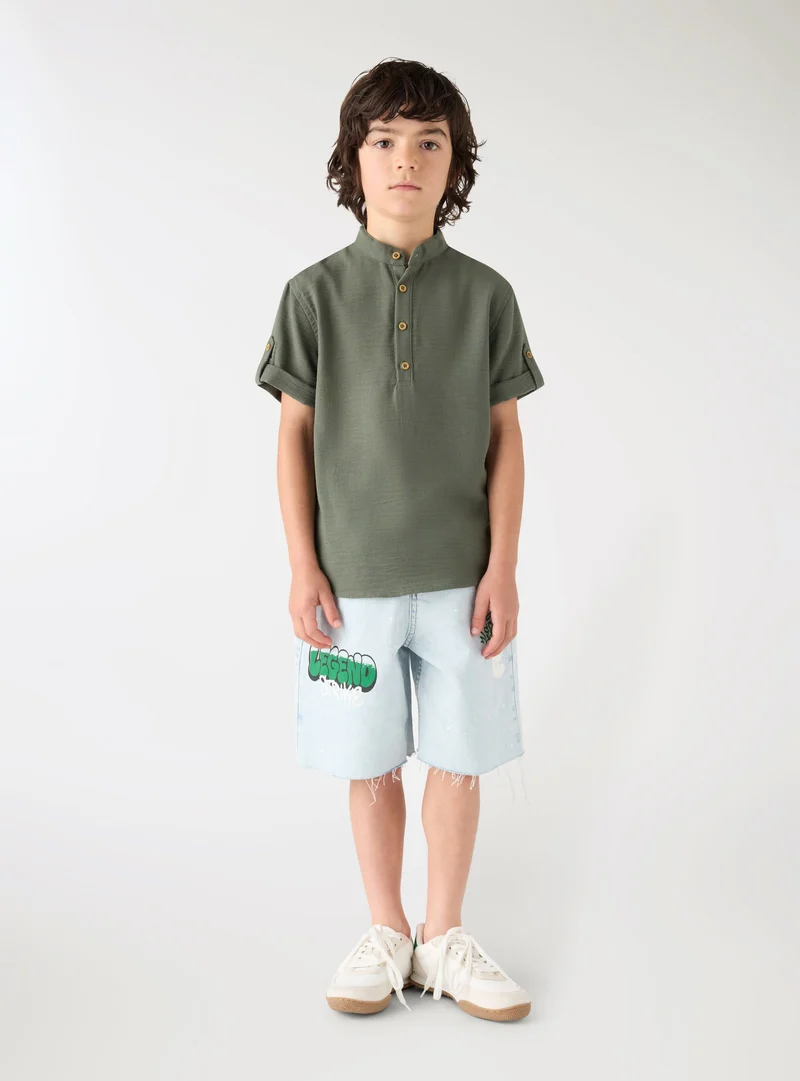 Pantaloncini jeans con stampa graffiti e strappi