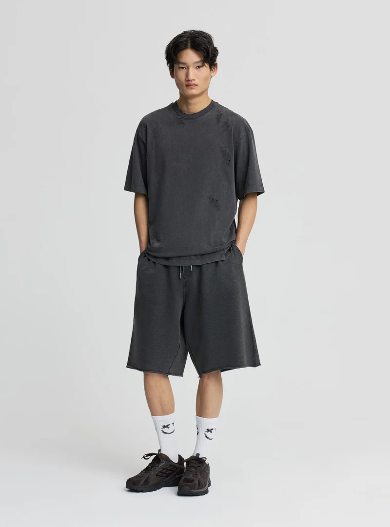 T-shirt boxy con strappi effetto acid wash