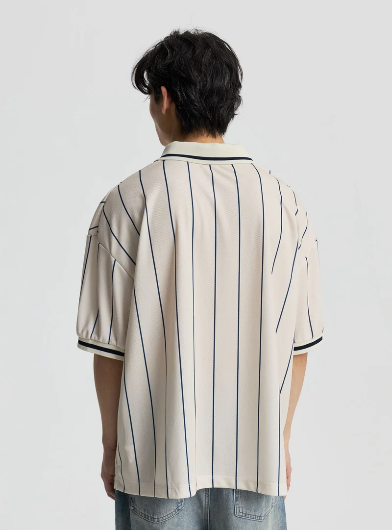 T-shirt stile calcio a righe con stampa lettering e collo polo