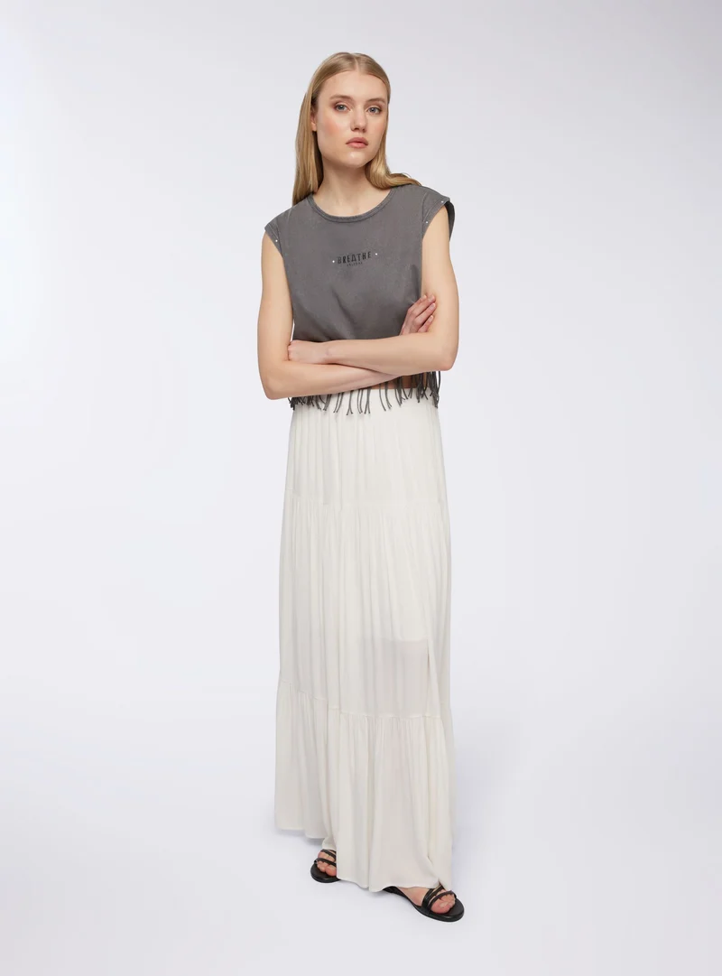 T-shirt ampia garment-dyed con frange e borchie