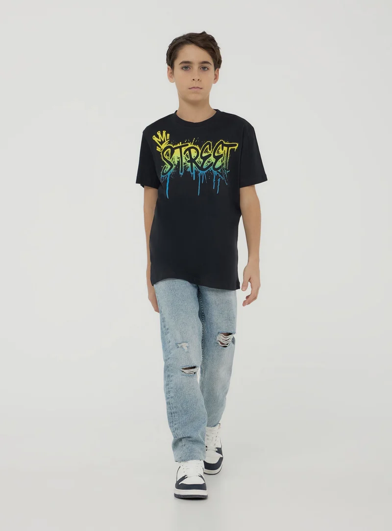 T-shirt con scritta in stile graffiti