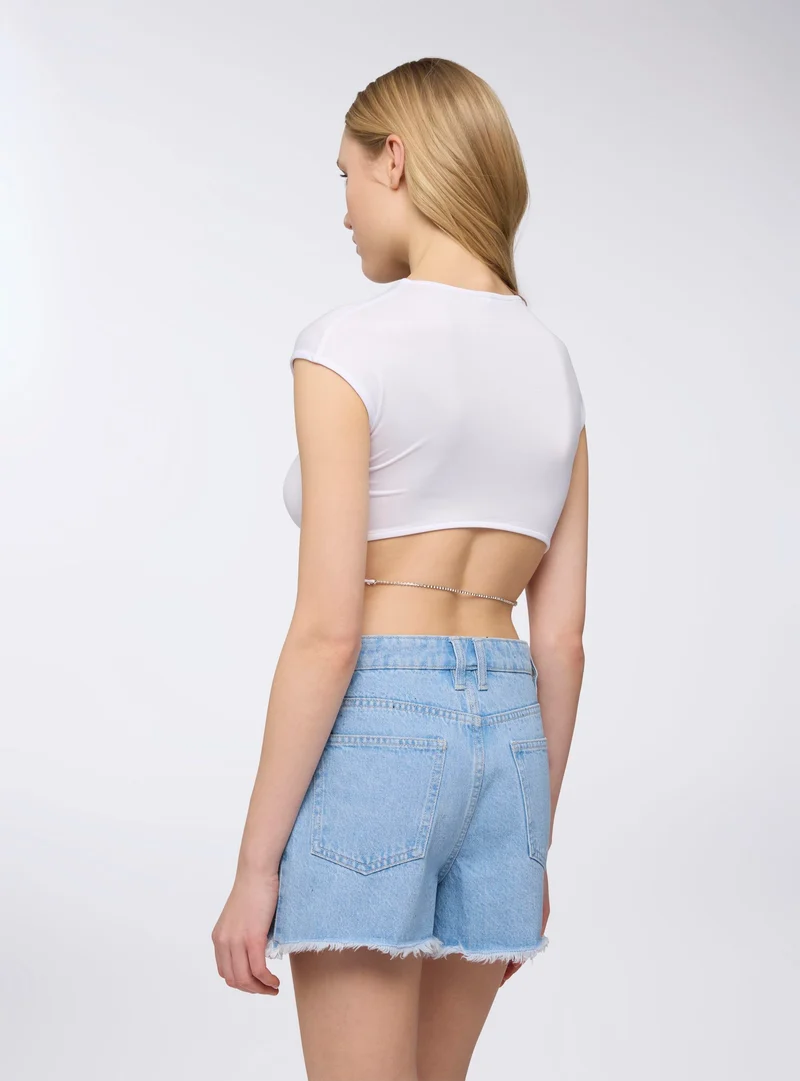 T-shirt con oblò e strass sul retro