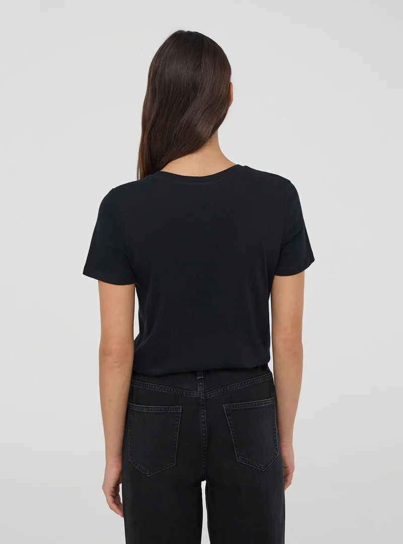T-shirt con scritta laminata