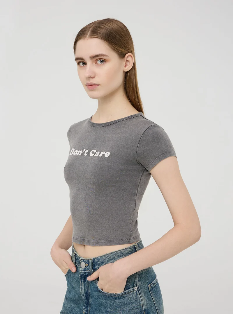 T-shirt crop garment-dyed con messaggio