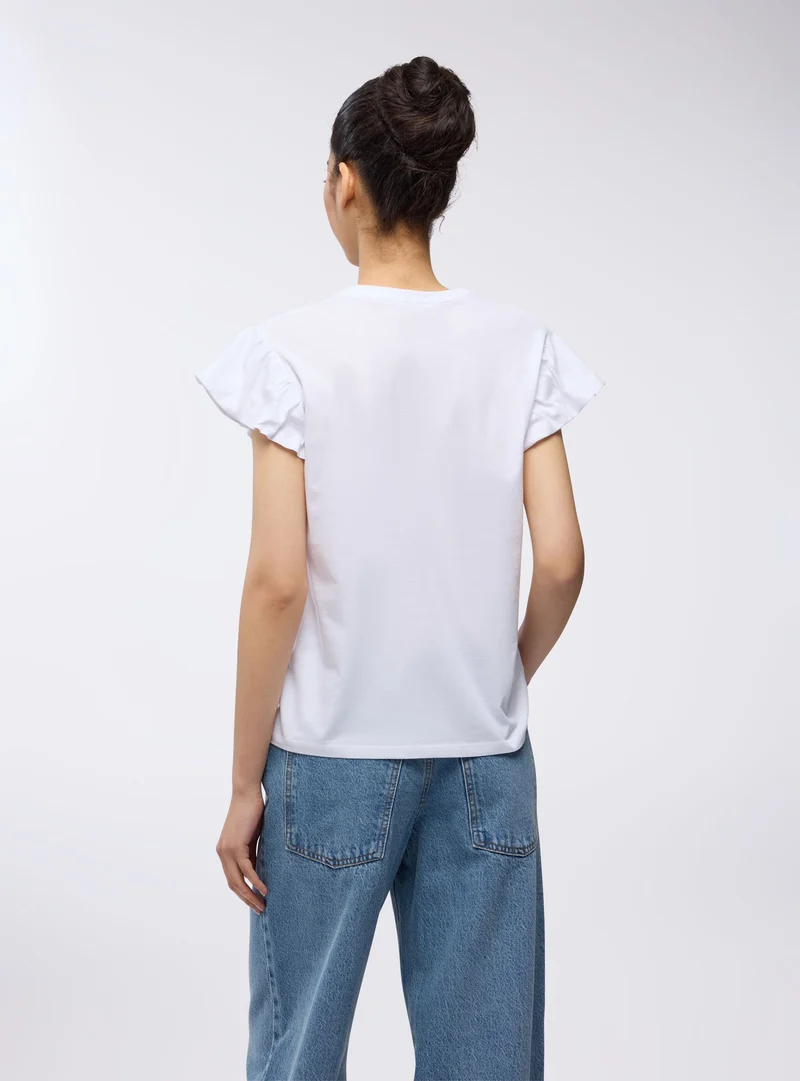 T-shirt con scritta e applicazioni