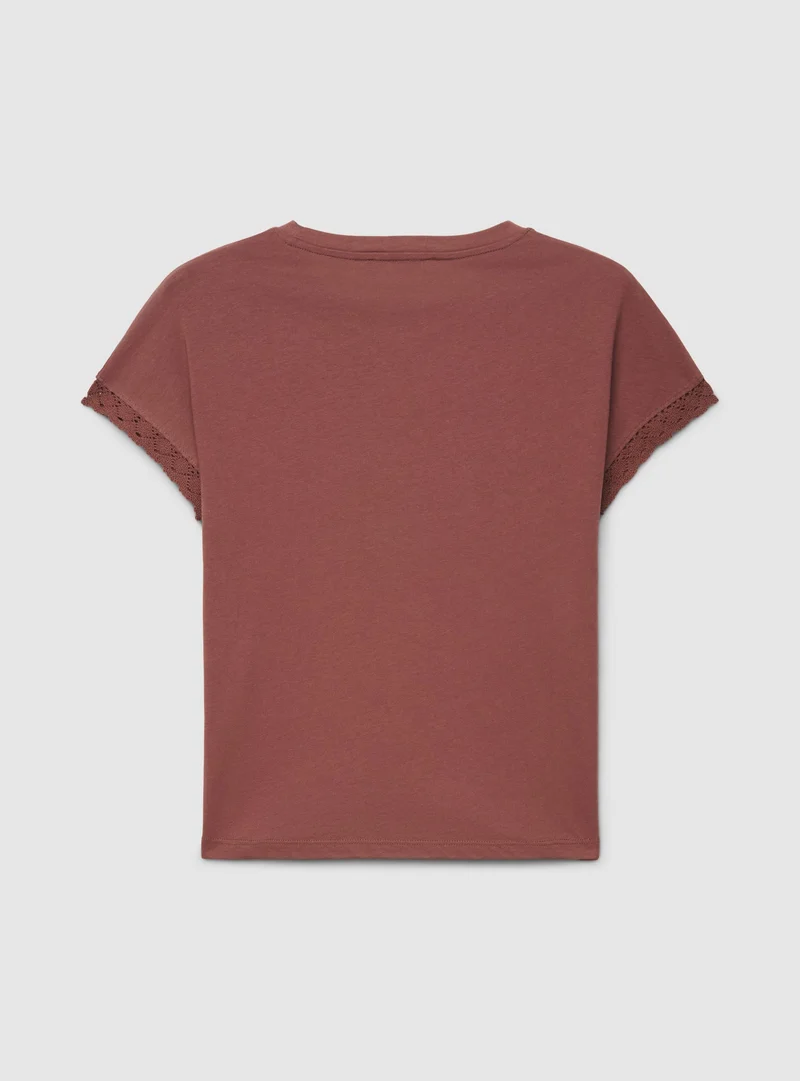 T-shirt con scritta traforata e bordo macramè