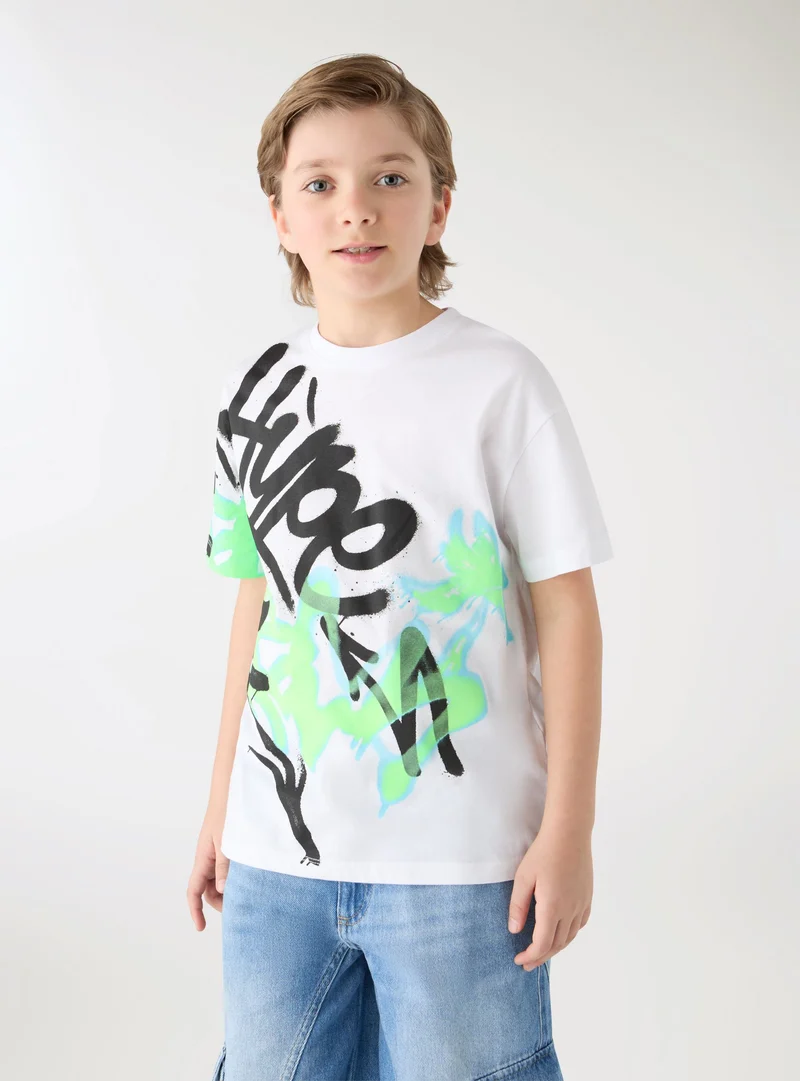T-shirt con stampa graffiti e scritta