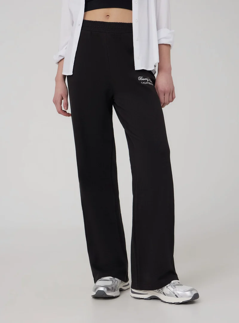 Pantaloni tuta wide leg con ricamo college