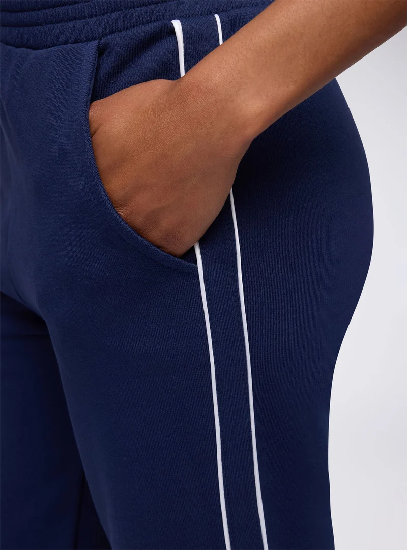 Pantaloni tuta wide leg con banda laterale