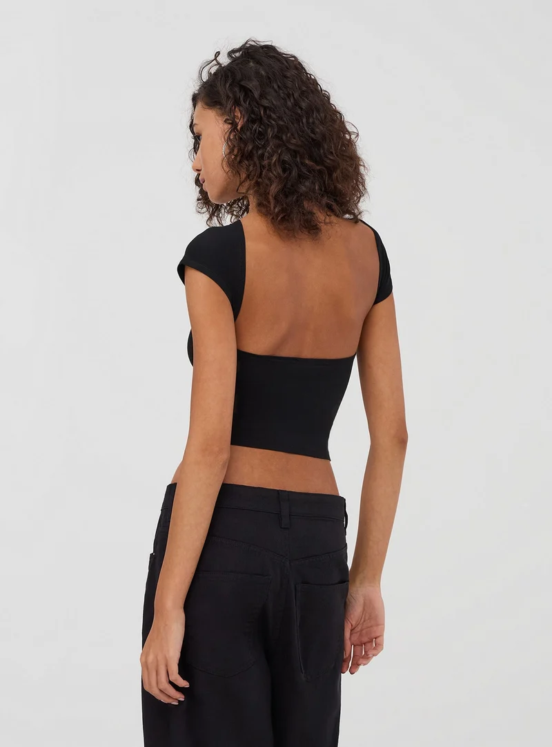 T-shirt crop con scritta e scollo sul retro