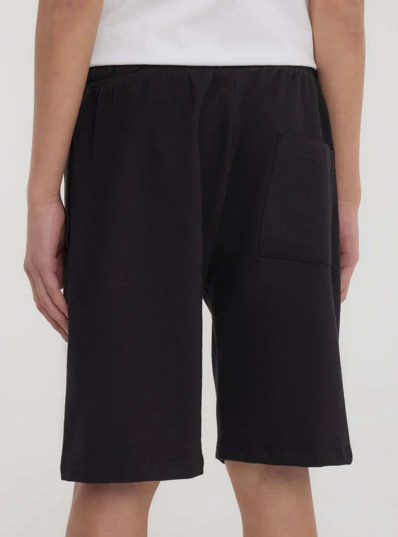 Pantaloncini tuta con scritta in stile gotico