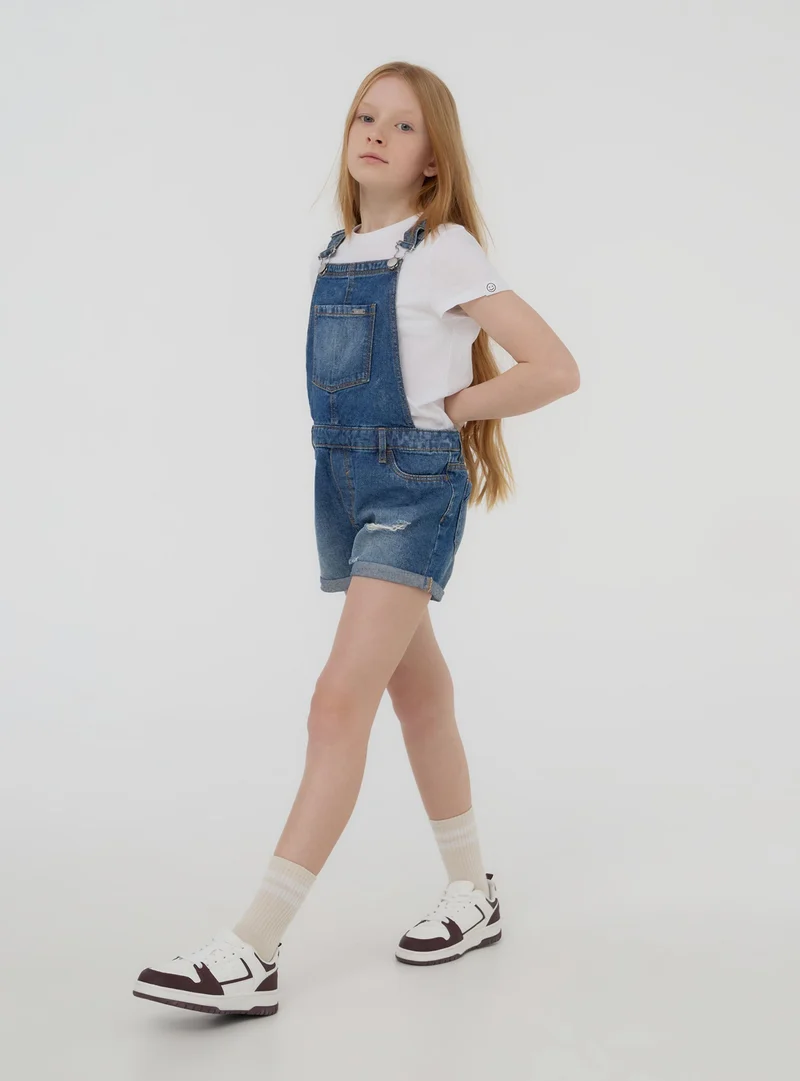 Salopette in jeans medio con strappi