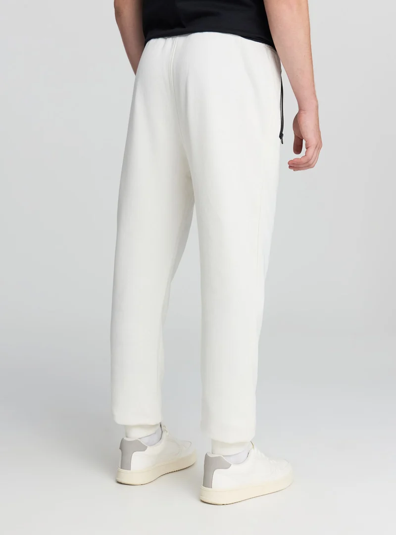 Pantaloni tecnici con coulisse e scritta