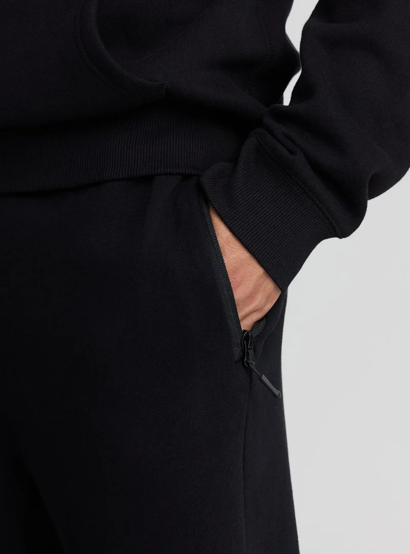 Pantaloni tecnici con tasche con zip