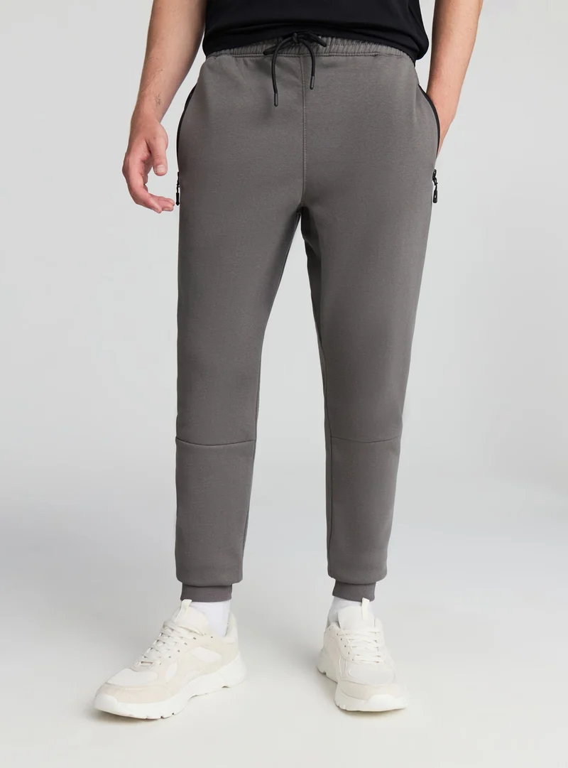 Pantaloni tecnici con tasche con zip