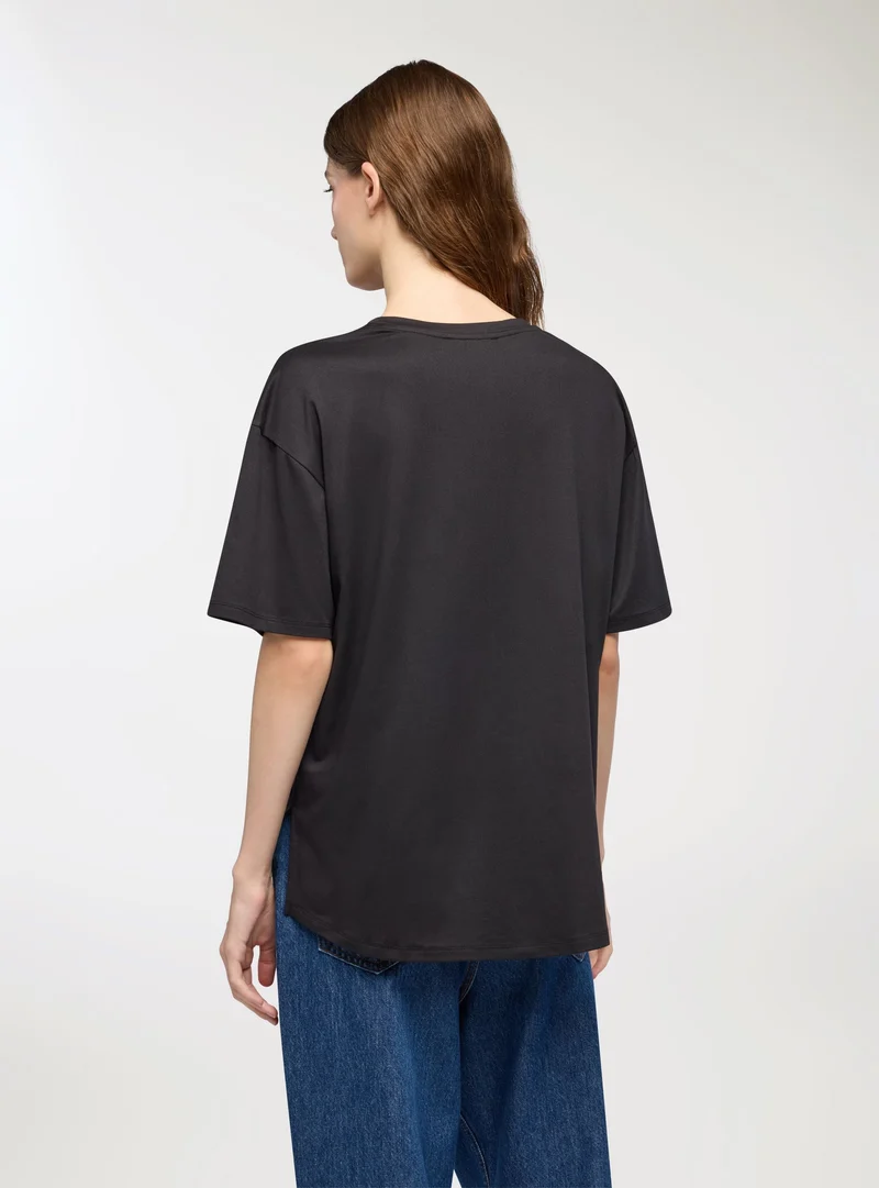 T-shirt con stampa volto e farfalle