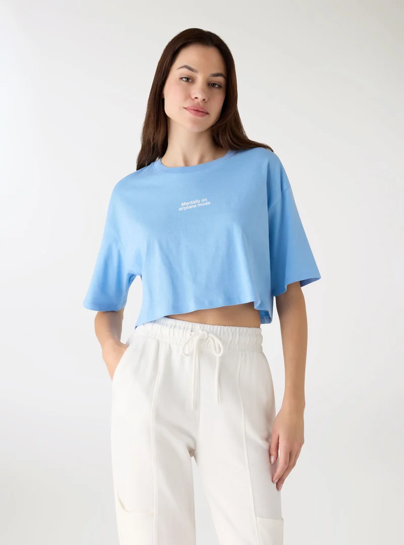 T-shirt crop ampia con scritta