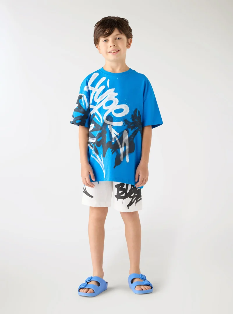 T-shirt con stampa graffiti e scritta
