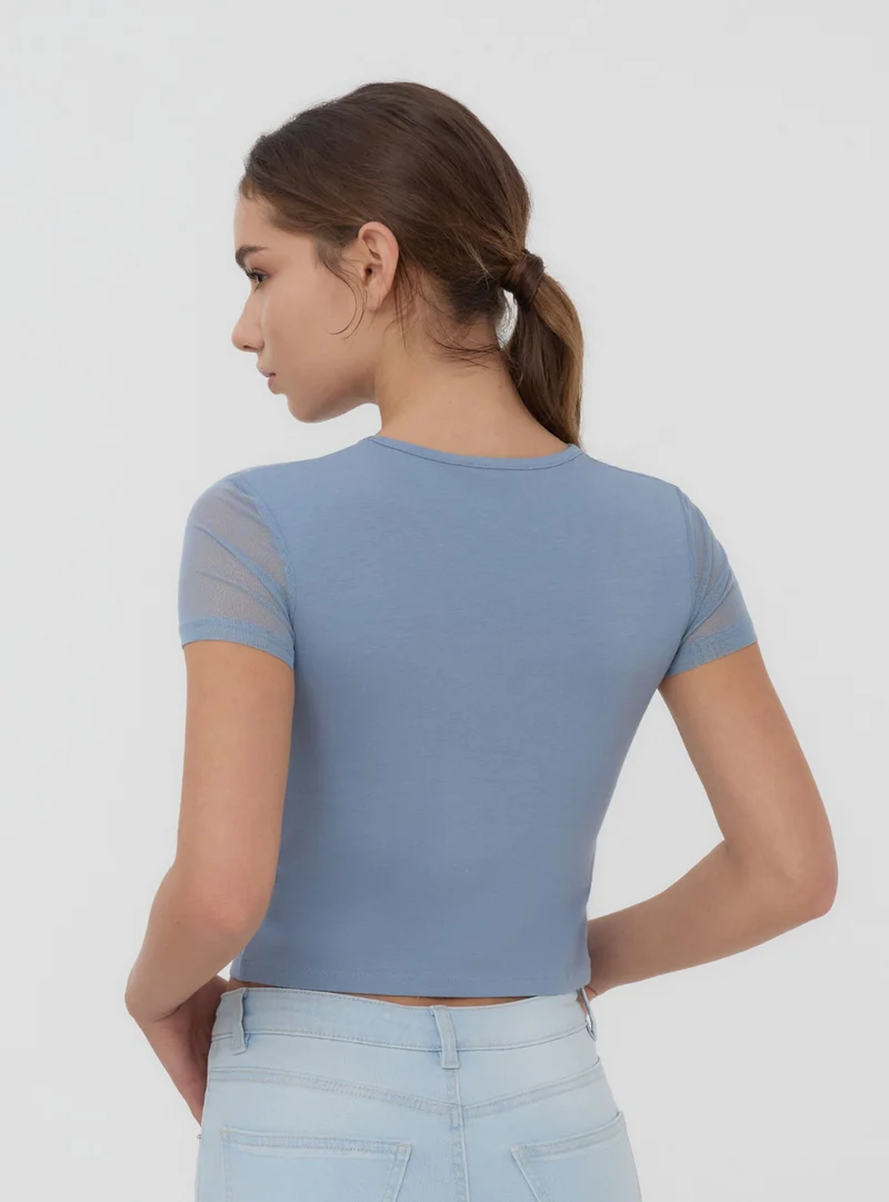 T-shirt crop aderente con scritta e inserto tulle