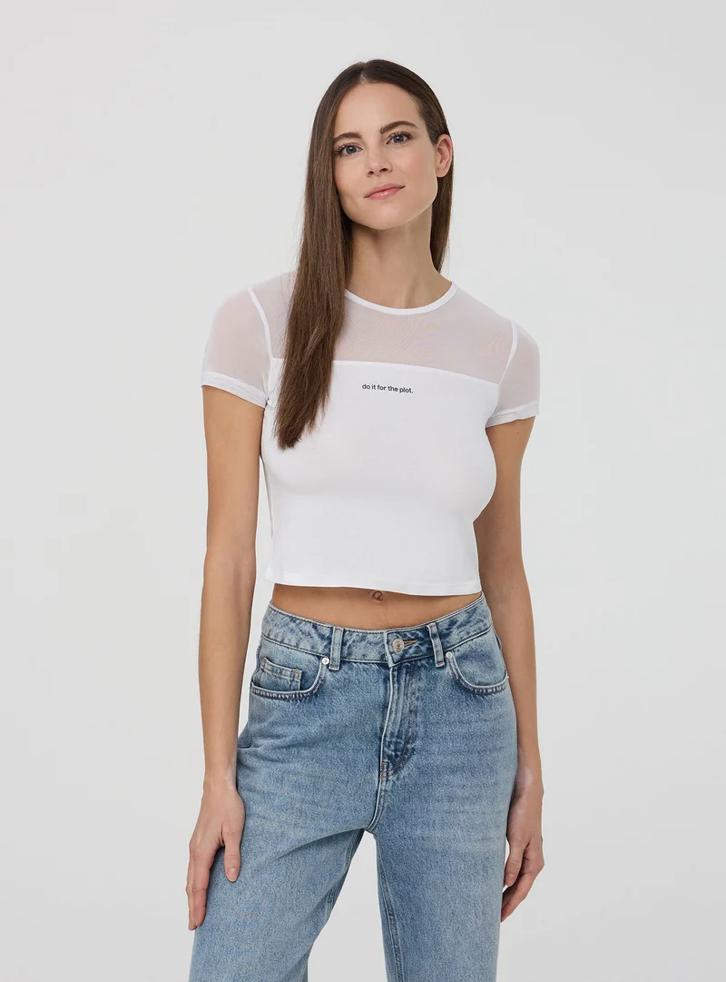 T-shirt crop aderente con scritta e inserto tulle
