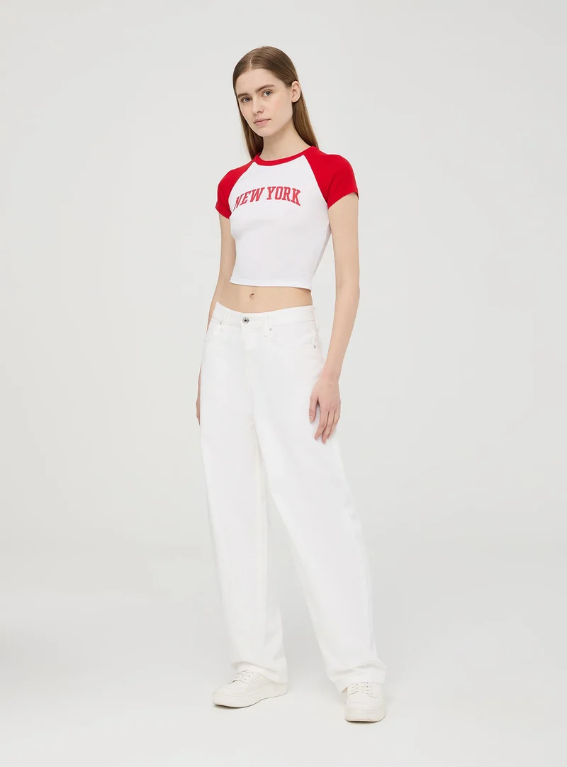 T-shirt crop raglan con stampa college