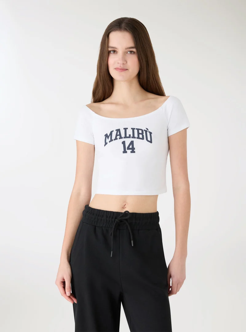 T-shirt crop con stampa e spalle scoperte