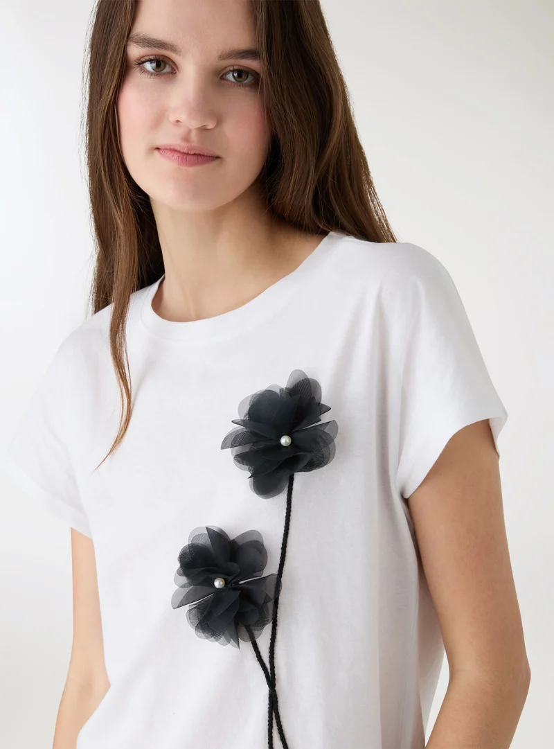 T-shirt con applicazioni floreali