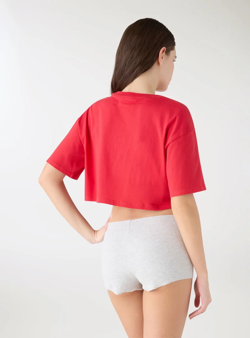 T-shirt crop ampia con scritta