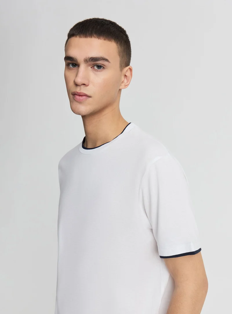 T-shirt a tinta unita con bordi a contrasto