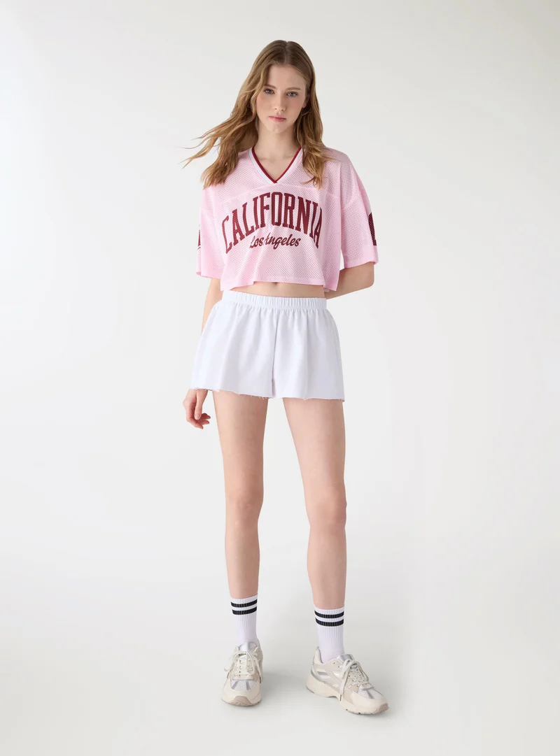 T-shirt crop a rete con stampa college