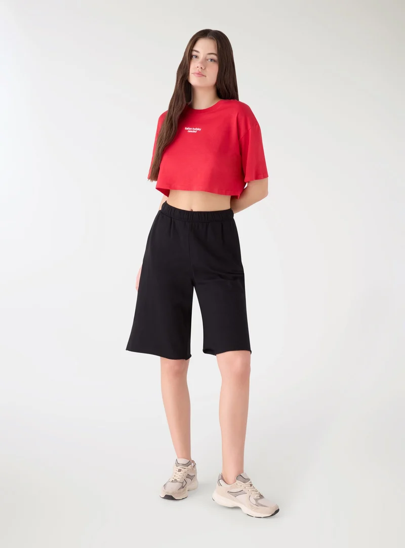T-shirt crop ampia con scritta