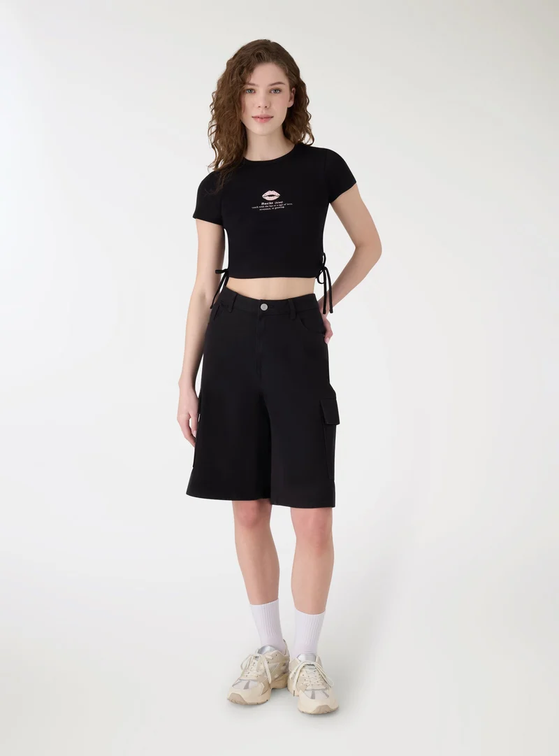 T-shirt crop con stampa bacio e lacci