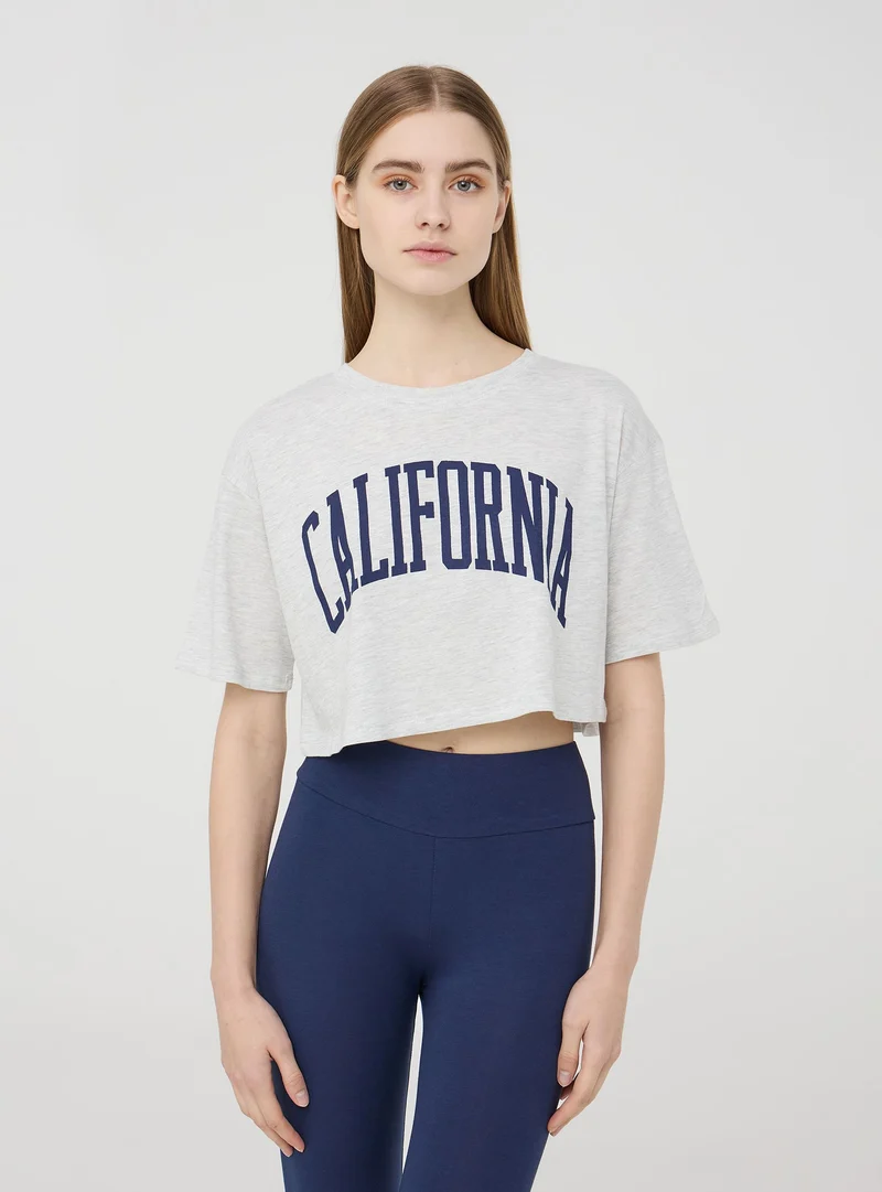 T-shirt crop ampia con stampa college
