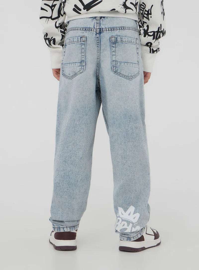 Jeans con strappi e stampe stile graffiti