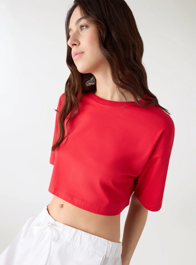 T-shirt crop ampia a tinta unita