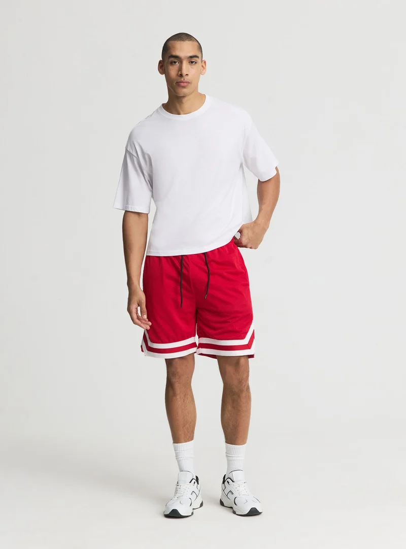 Pantaloncini in rete stile basket con bande a contrasto