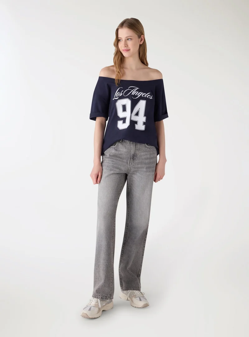T-shirt maxi a spalle scoperte con stampa college