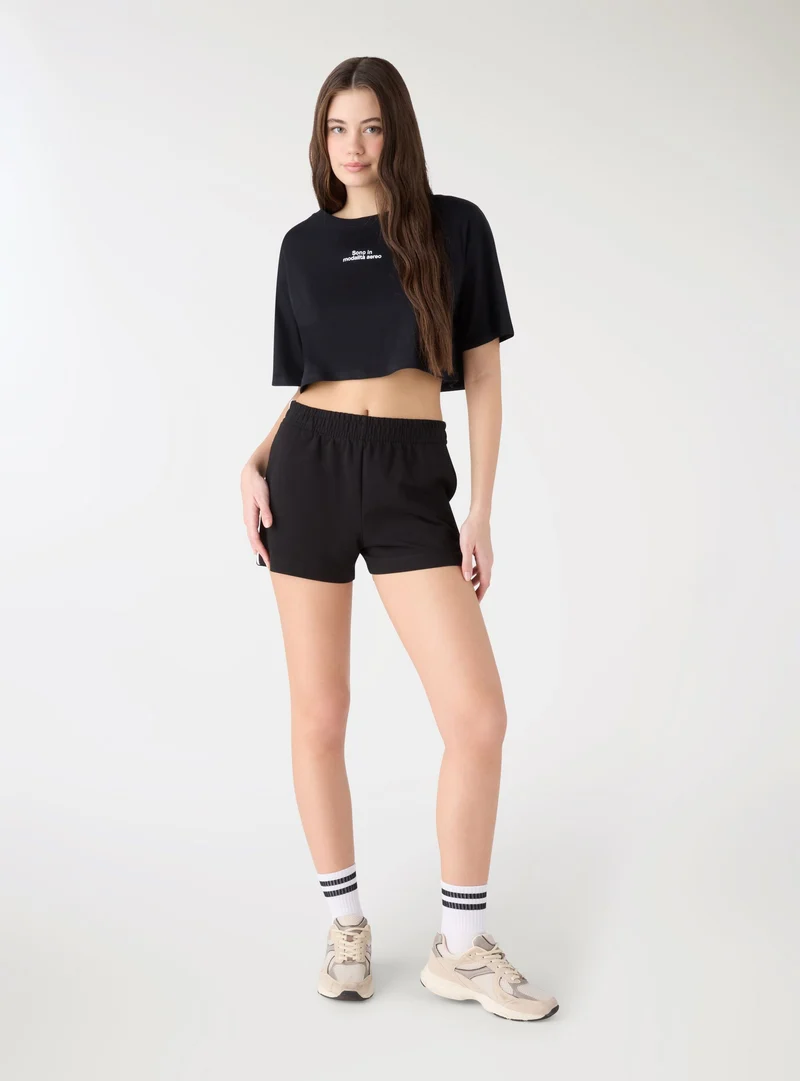 T-shirt crop ampia con scritta