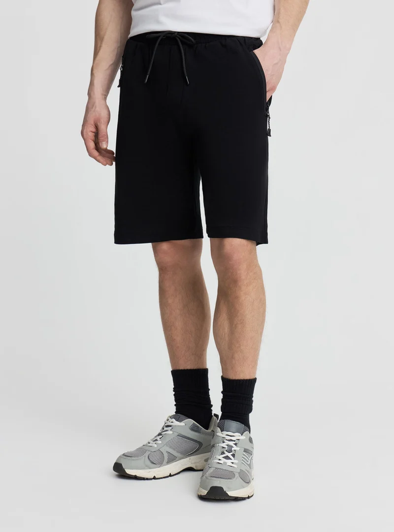 Bermuda tecnico con tasche zip